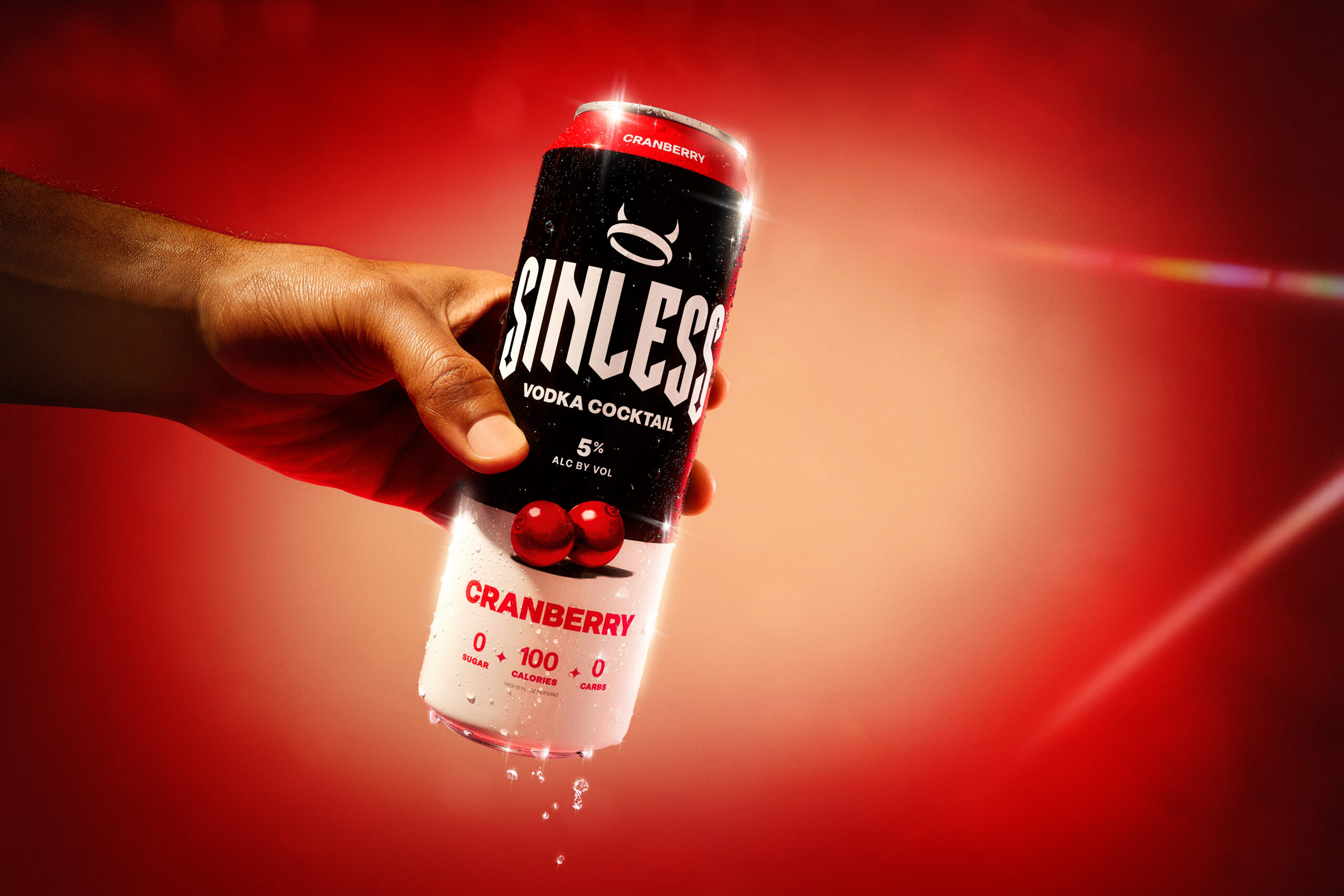 A hand holding a can of Sinless Cranberry Vodka Cocktail