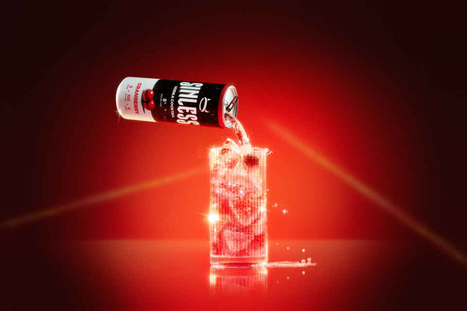 A can of Sinless Cranberry being poured into a glass with ice.